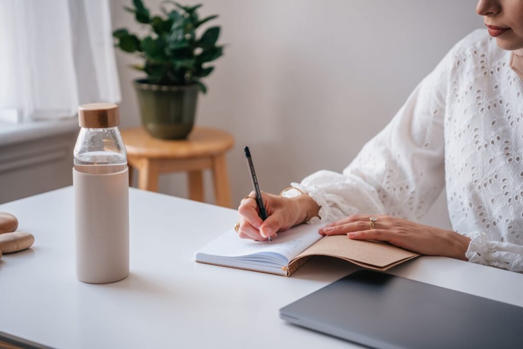Woman writing in journal to track her healthy habits